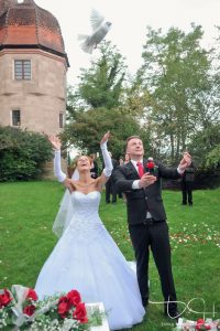 Der alte Brauch Tauben steigen zu lassen, nach der kirchlichen Trauung - Fotograf Hochzeit