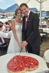 Alter Brauch beim Anschnitt der Hochzeitstorte. Wer hand die Hand oben? Der Hochzeitsfotograf macht die passenden Bilder