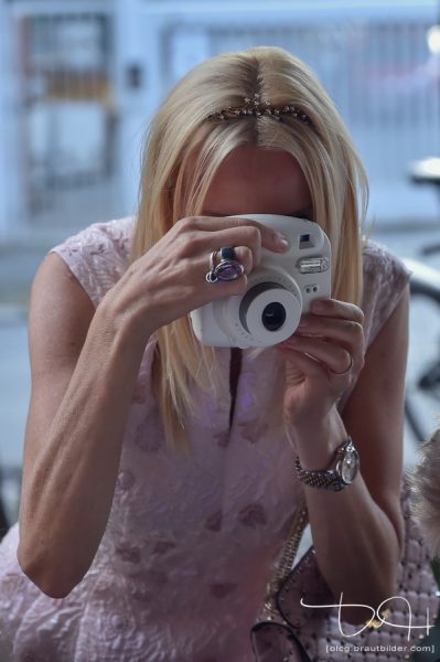 Die Braut fotografiert mal selbst! Der Hochzeitsfotograf haelt es mit der Kamera fest.