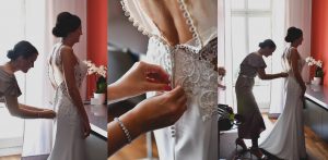 Die Braut schluepft in ihr Brautkleid und der Hochzeitsfotograf macht die Bilder.