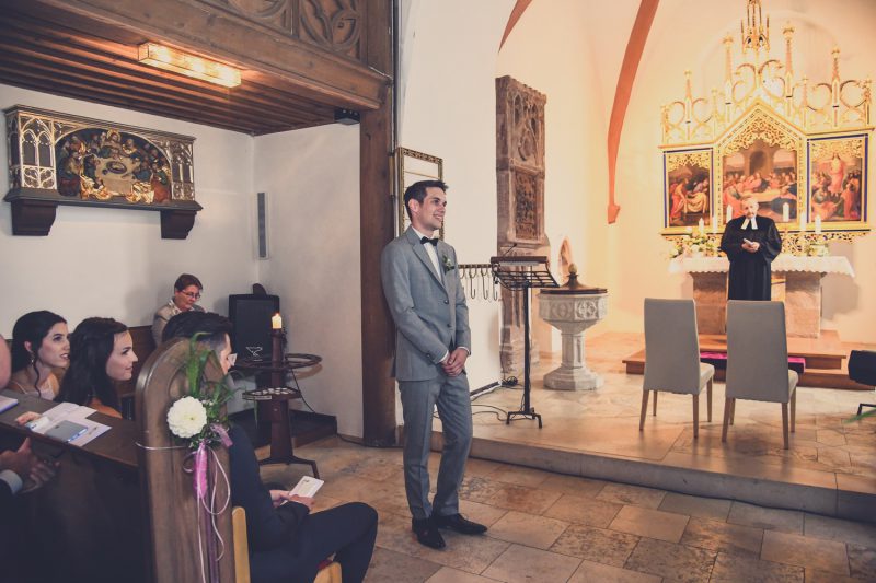 Der Braeutigam lauscht gespannt. Hochzeitsfotograf aus Nuernberg macht die Bilder.